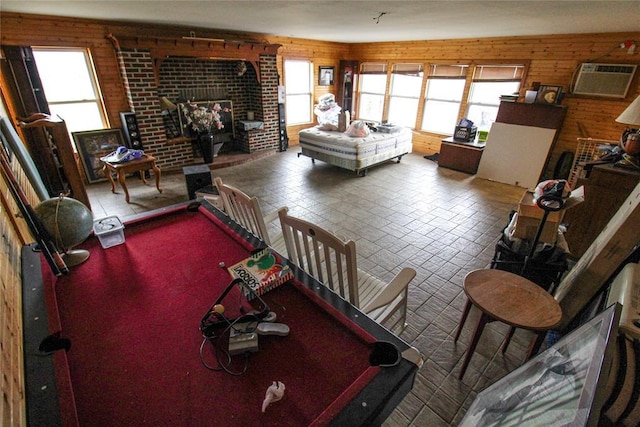 living area with pool table, an AC wall unit, plenty of natural light, and wood walls