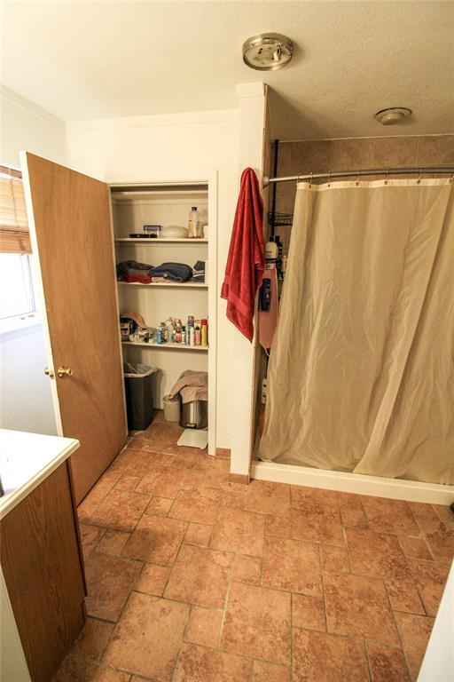 bathroom with curtained shower, vanity, and stone finish floor