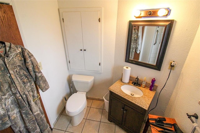 bathroom featuring tile patterned floors, baseboards, toilet, and vanity