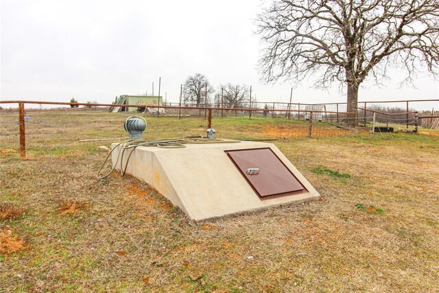 view of storm shelter with a yard and fence