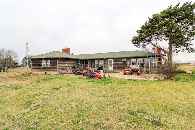 back of property with a lawn, a chimney, and a patio area