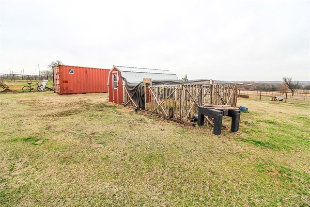 view of yard with an outbuilding, a shed, and fence