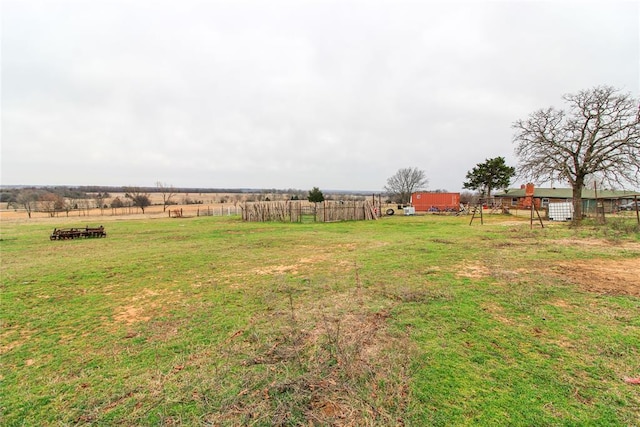 view of yard with a rural view and fence