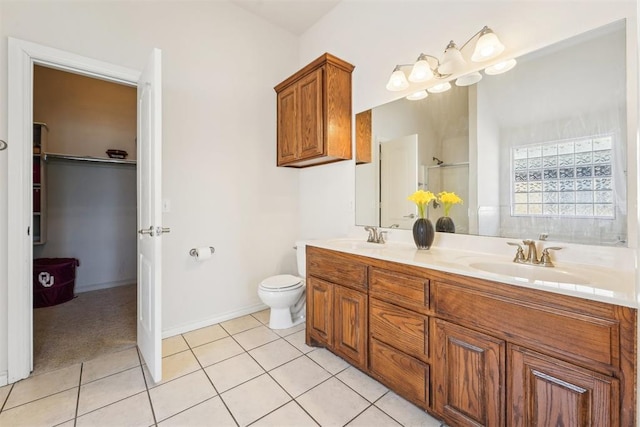 bathroom featuring a sink, a shower, double vanity, and tile patterned flooring