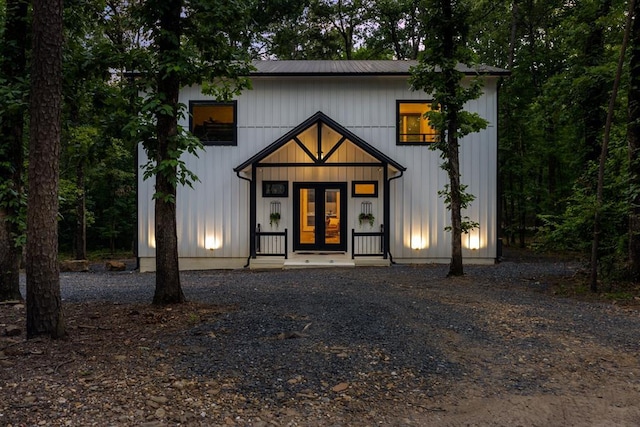 modern farmhouse style home with metal roof, board and batten siding, and french doors