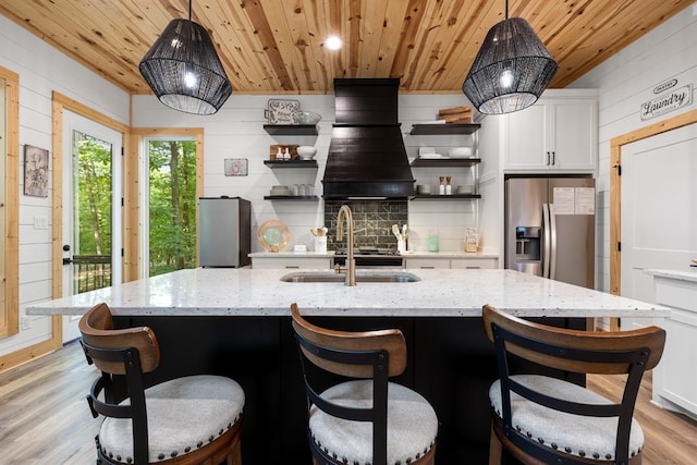 kitchen with wooden ceiling, white cabinetry, stainless steel refrigerator with ice dispenser, freestanding refrigerator, and open shelves