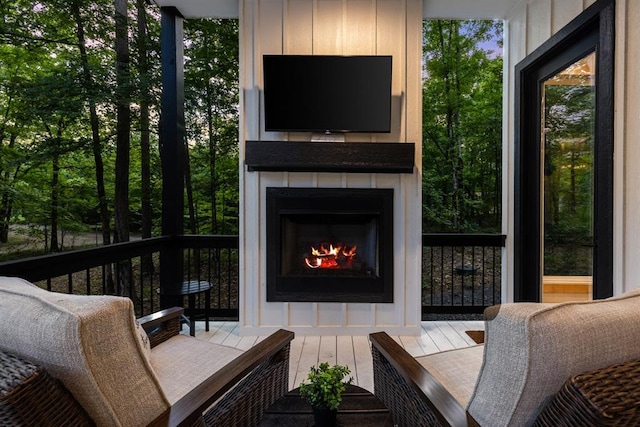 deck featuring a warm lit fireplace