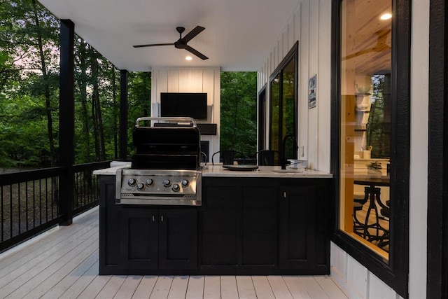 wooden terrace featuring ceiling fan, grilling area, and a sink