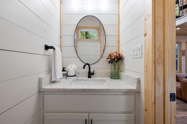 bathroom with wood walls and vanity