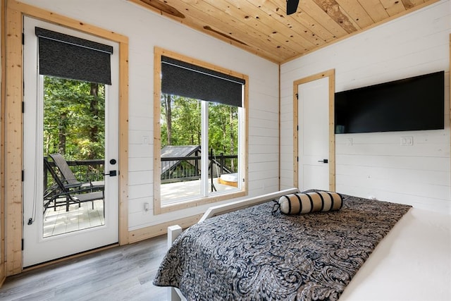 bedroom with wooden ceiling, access to outside, wooden walls, and wood finished floors