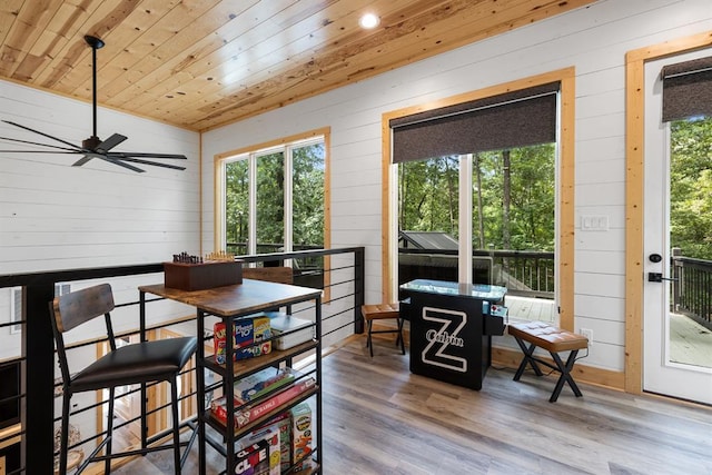 dining area featuring a wealth of natural light, wood ceiling, wooden walls, and wood finished floors