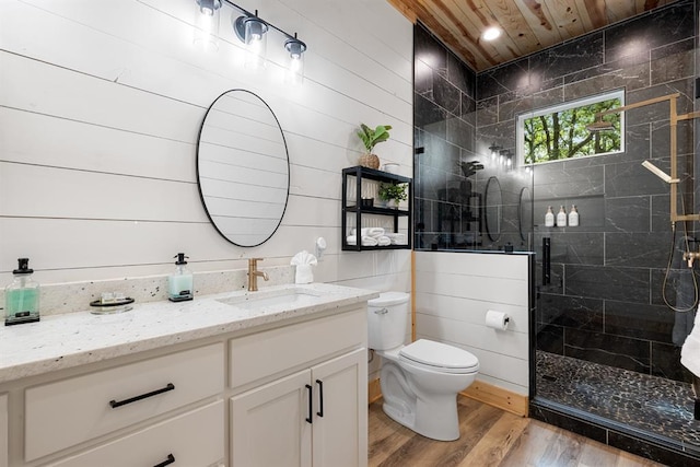 bathroom with a stall shower, toilet, wood ceiling, wood finished floors, and vanity