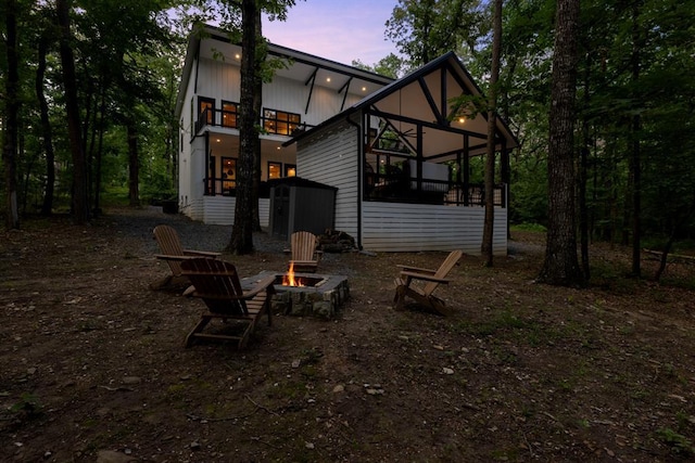 rear view of property with a fire pit and a sunroom