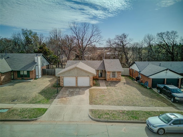 view of front facade featuring concrete driveway, an attached garage, fence, and roof with shingles