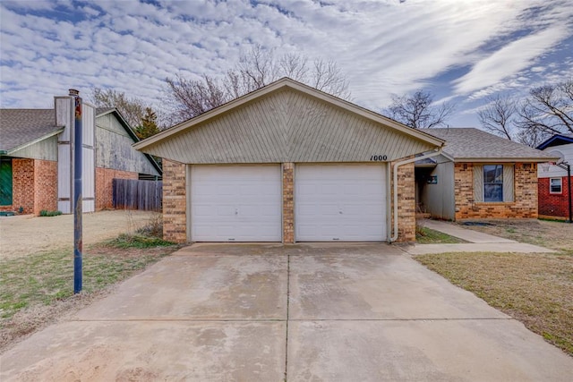 ranch-style home featuring an attached garage, fence, brick siding, and roof with shingles