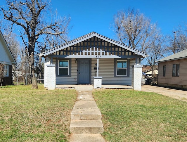 bungalow-style home featuring a porch, a front yard, and fence