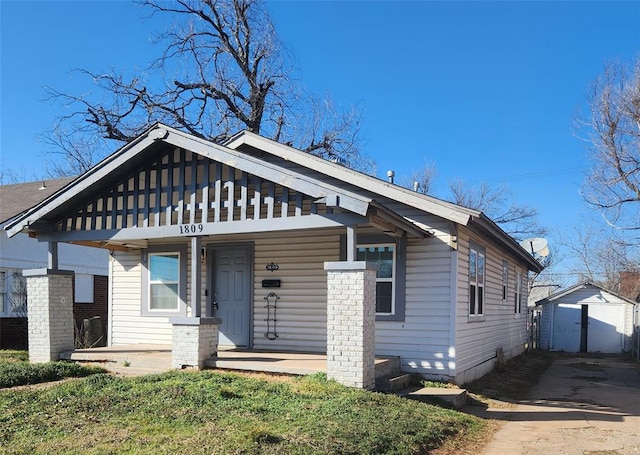 view of front of property with an outdoor structure and covered porch