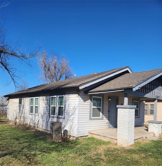 rear view of property featuring a lawn