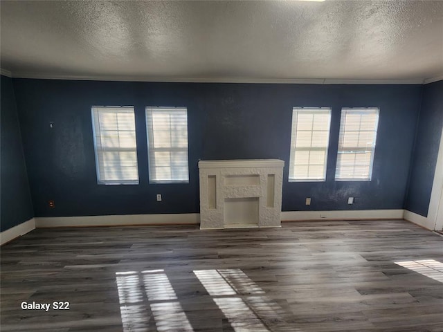 unfurnished living room featuring wood finished floors, a high end fireplace, and ornamental molding