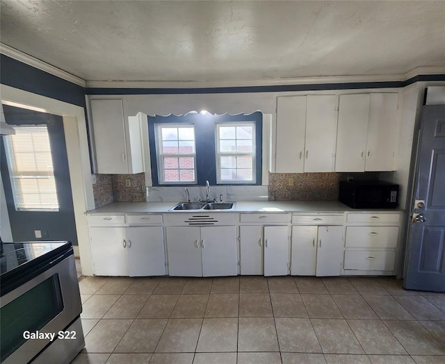 kitchen with a sink, stainless steel electric stove, white cabinets, black microwave, and light countertops