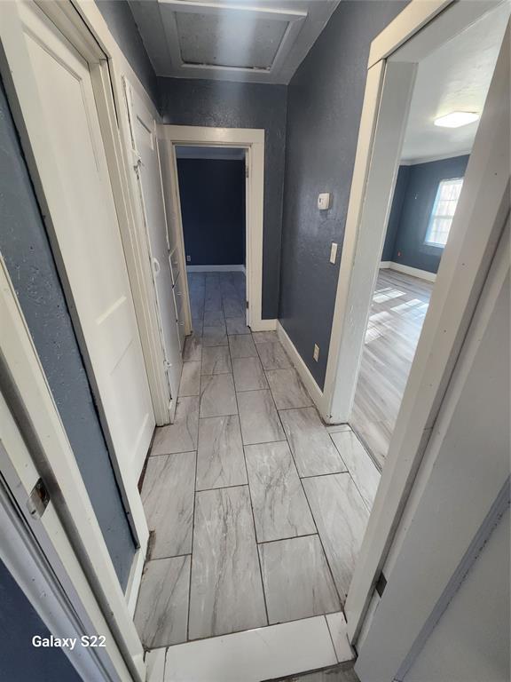 hall featuring baseboards and marble finish floor