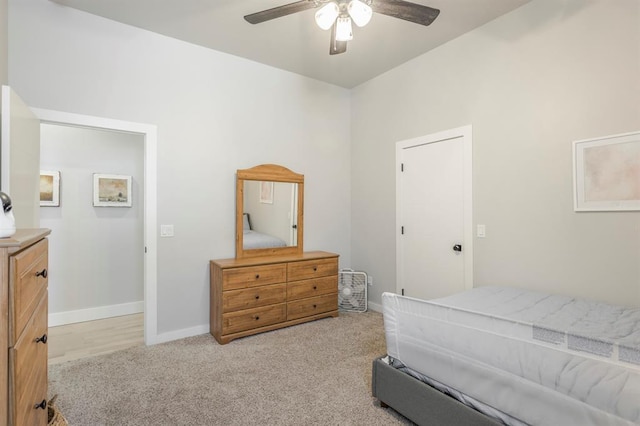 bedroom with light colored carpet, baseboards, and ceiling fan