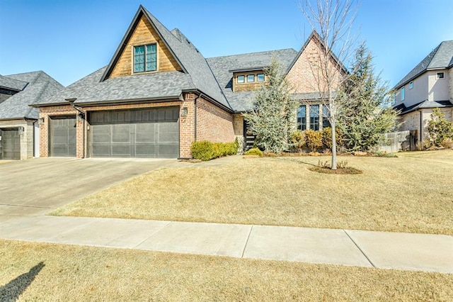 view of front of house with roof with shingles, an attached garage, concrete driveway, a front lawn, and brick siding