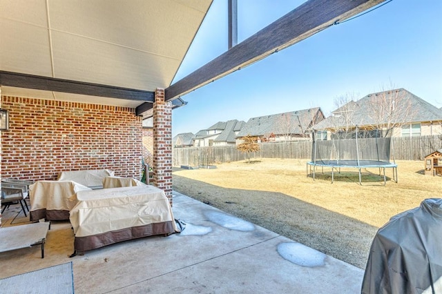 view of patio / terrace featuring a fenced backyard, a grill, and a trampoline