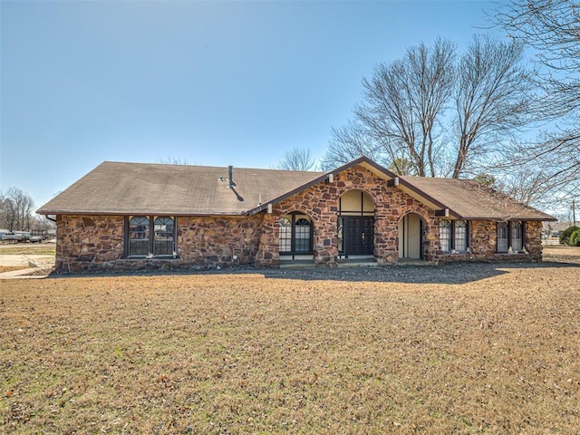 view of front of property with stone siding and a front lawn