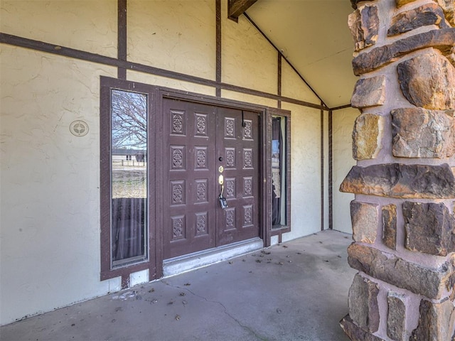 doorway to property featuring stucco siding