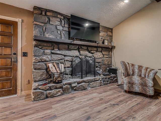 details with a fireplace, a textured ceiling, and wood finished floors