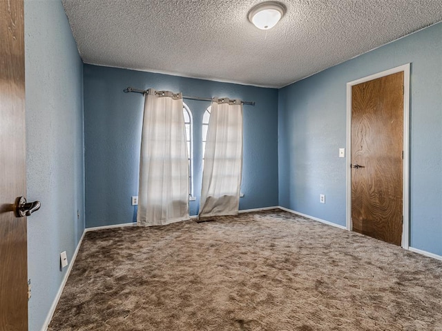 unfurnished room featuring a textured ceiling, a textured wall, and carpet floors