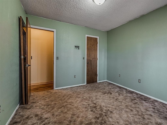 unfurnished bedroom with baseboards, carpet, and a textured ceiling