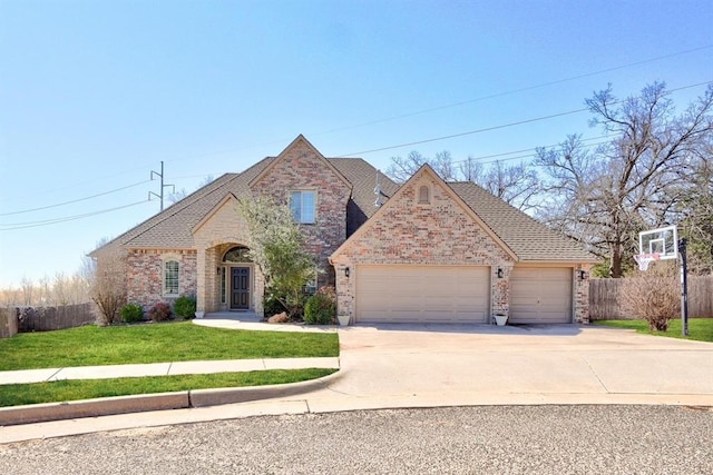 view of front of property with a front yard, fence, an attached garage, concrete driveway, and brick siding