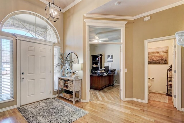 entrance foyer with crown molding, plenty of natural light, wood finished floors, and baseboards