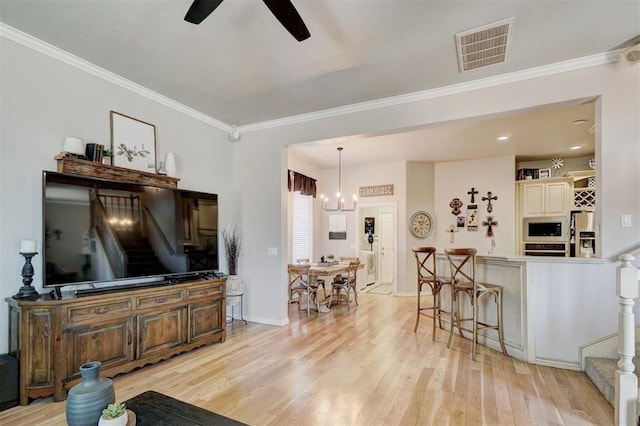 living room featuring visible vents, stairway, crown molding, and light wood finished floors