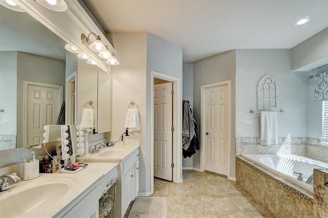 full bath featuring a sink, a garden tub, double vanity, and tile patterned flooring