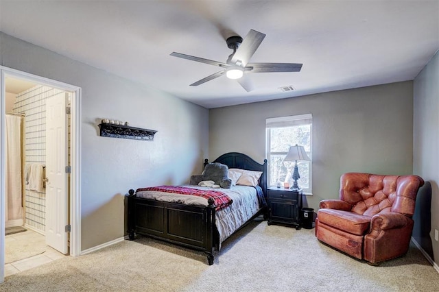 bedroom featuring visible vents, light carpet, ensuite bathroom, baseboards, and ceiling fan