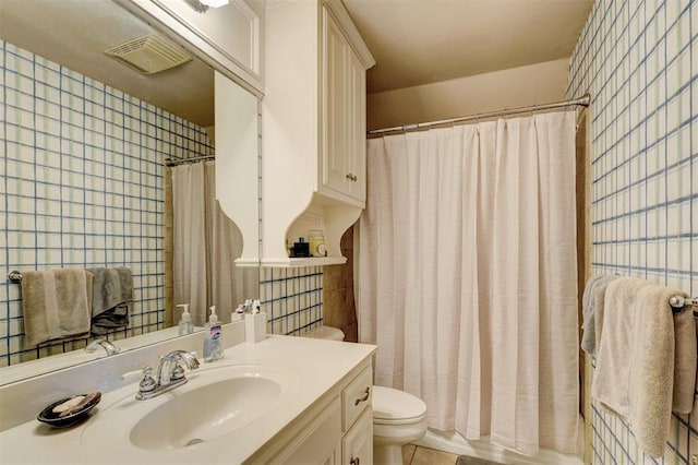 full bathroom featuring vanity, visible vents, curtained shower, tile walls, and toilet