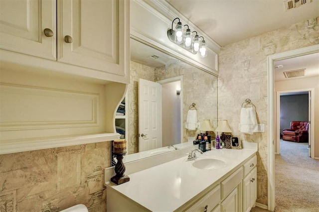 bathroom featuring visible vents, ornamental molding, and vanity