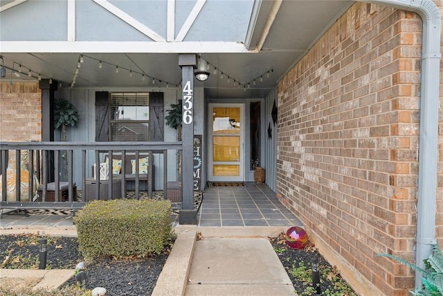 property entrance with covered porch and brick siding