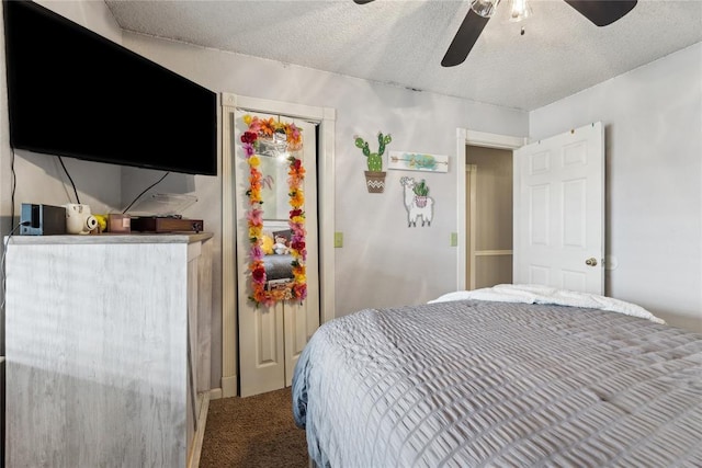 carpeted bedroom with a textured ceiling and a ceiling fan