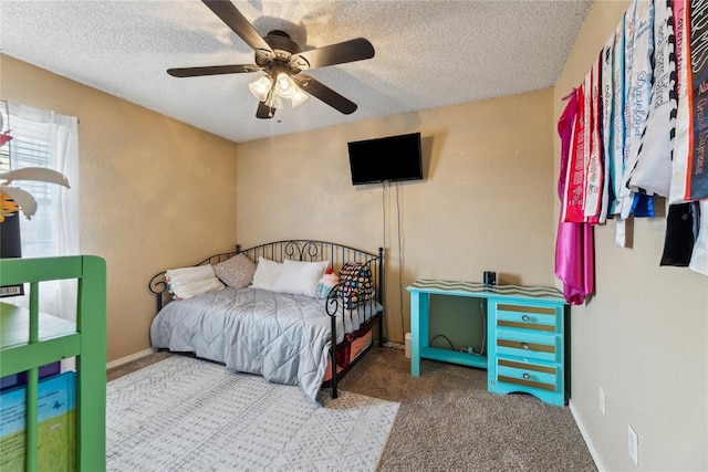 bedroom with baseboards, ceiling fan, a textured ceiling, and carpet