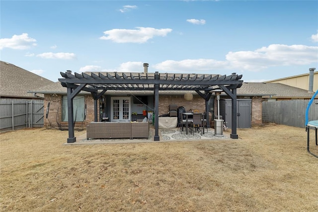 rear view of property with french doors, a trampoline, a fenced backyard, and a pergola