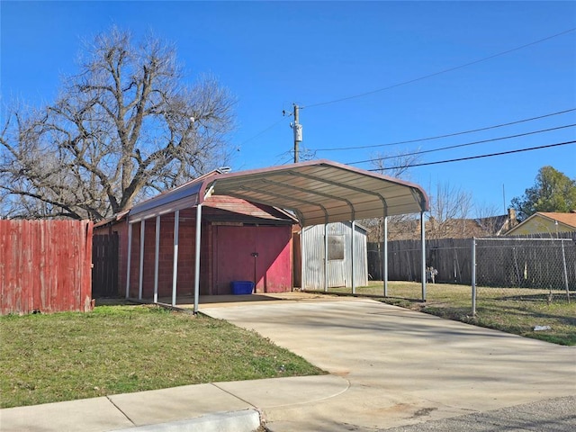 view of parking featuring a garage, fence, and a storage shed