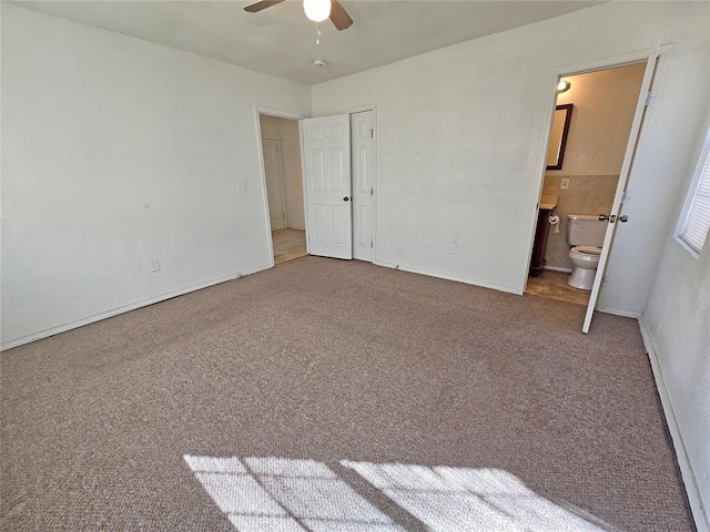 unfurnished bedroom featuring ensuite bathroom, carpet, a ceiling fan, and baseboards