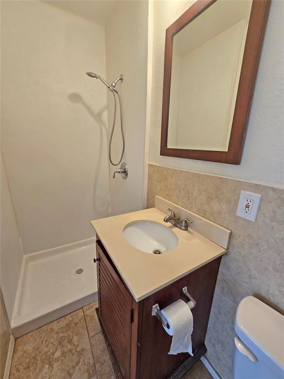 full bathroom with toilet, a stall shower, and vanity
