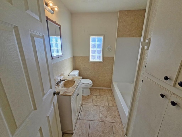 bathroom featuring a shower, toilet, a wainscoted wall, a washtub, and vanity