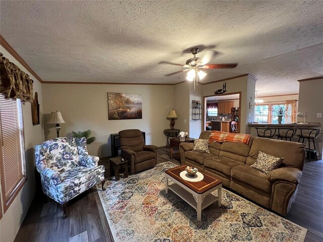 living area with ceiling fan, a textured ceiling, wood finished floors, and crown molding