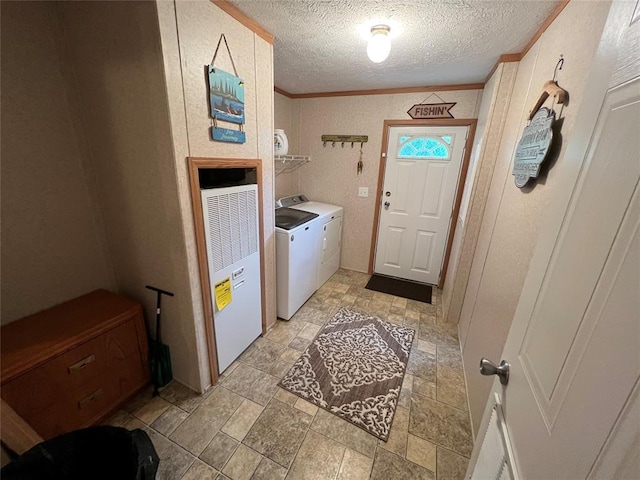 washroom with washing machine and clothes dryer, ornamental molding, laundry area, stone finish floor, and a textured ceiling